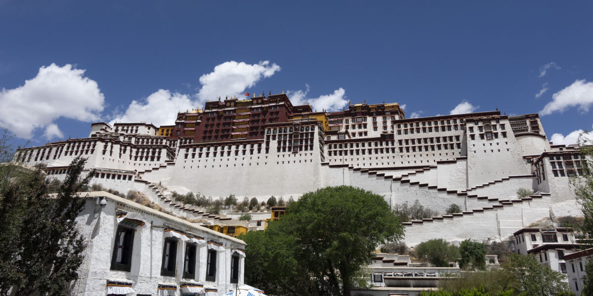 Potala Palace, a huge white fortress with many wooden shutters