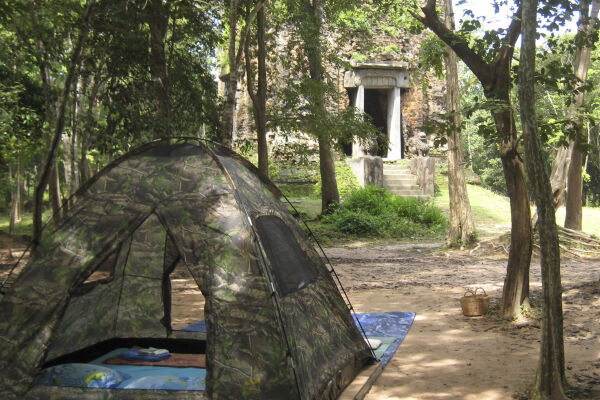 A light tent pitched in front of a Khmer ruin