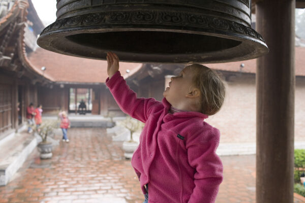 Little girl ringing a temple bell
