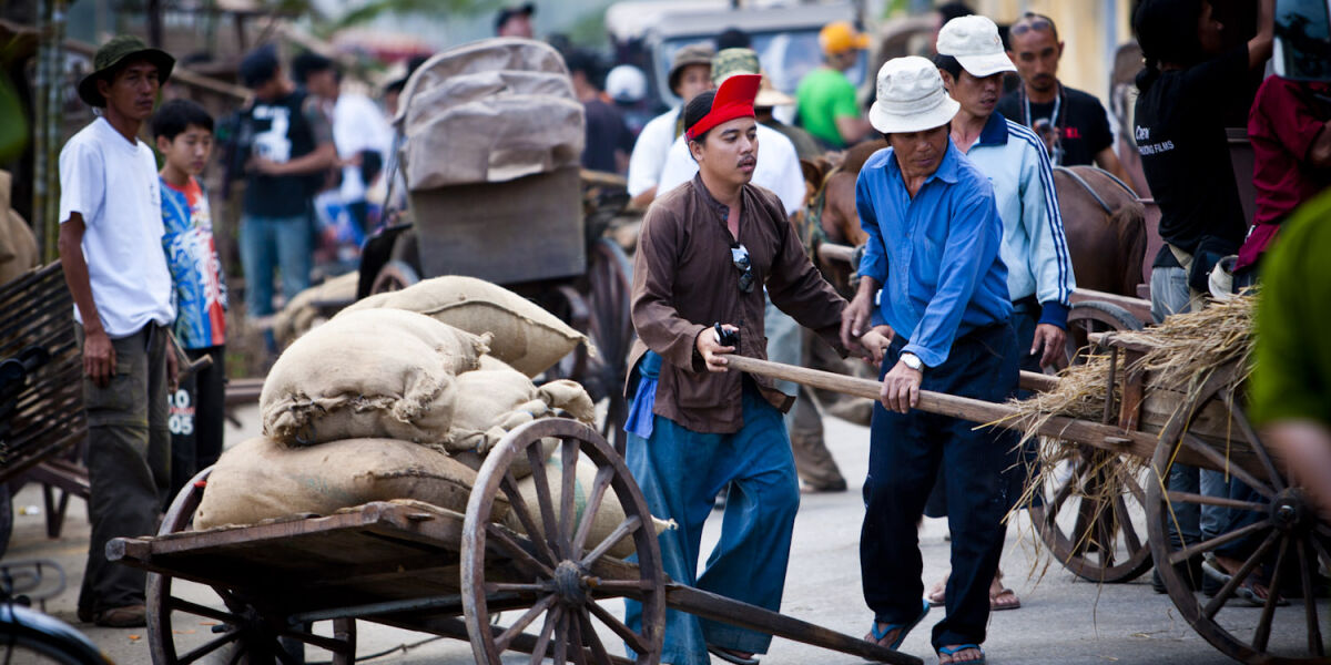 Men push a wooden handcart