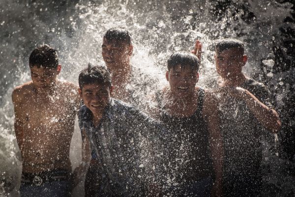 Young men dancing in water