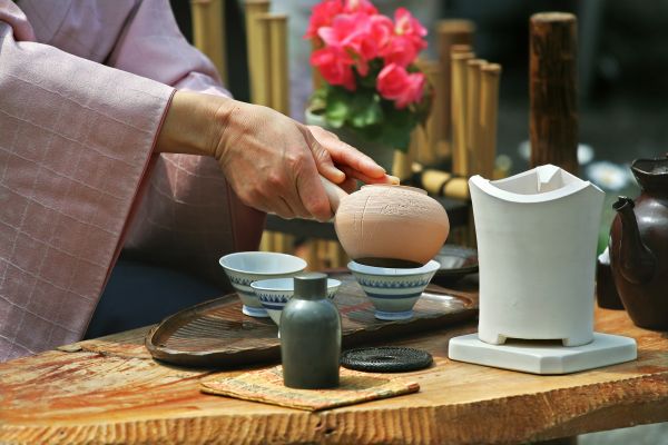 Lady dressed in a kimono pouring a teapot